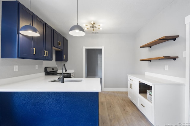 kitchen featuring open shelves, light wood-type flooring, a peninsula, and light countertops