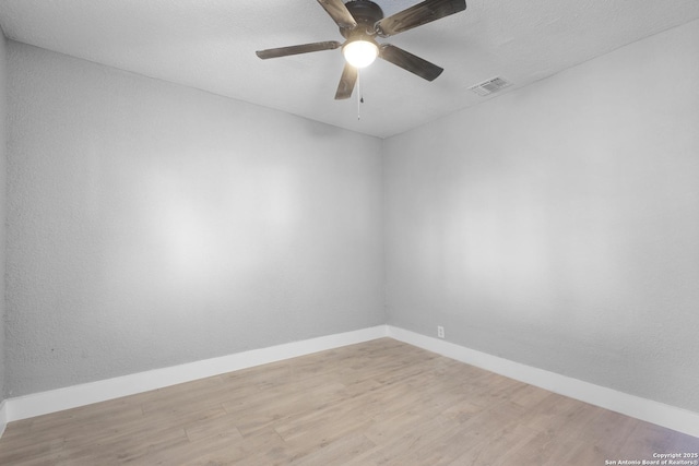 spare room featuring visible vents, baseboards, and wood finished floors