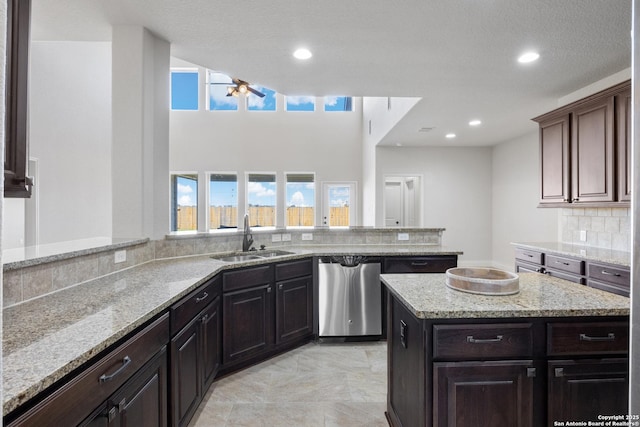 kitchen featuring light stone countertops, recessed lighting, a sink, decorative backsplash, and dishwasher