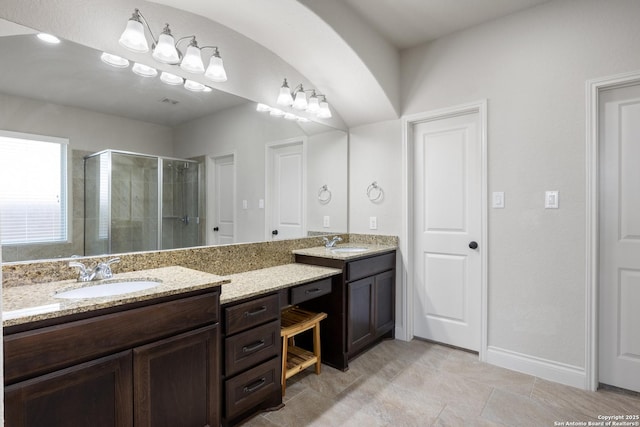 bathroom with a stall shower, vanity, and baseboards