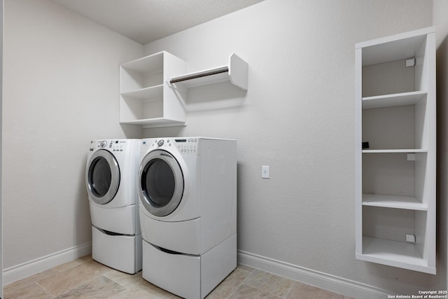 washroom featuring laundry area, washing machine and dryer, and baseboards