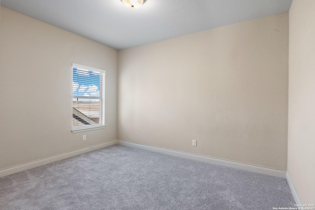 unfurnished room with baseboards and carpet flooring