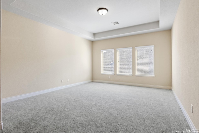 carpeted empty room featuring visible vents and baseboards