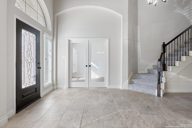 tiled entryway featuring stairs, french doors, and baseboards