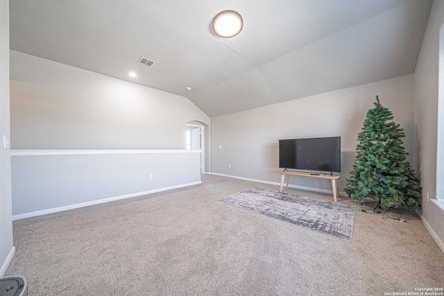 unfurnished living room with arched walkways, carpet flooring, visible vents, baseboards, and vaulted ceiling