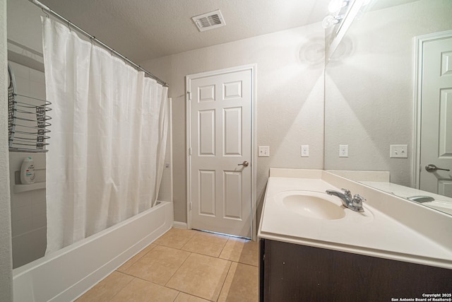 full bathroom with shower / bath combo, visible vents, tile patterned flooring, a textured ceiling, and vanity