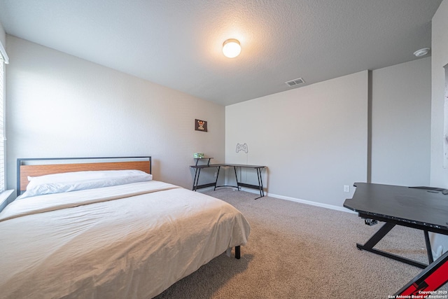 bedroom with a textured ceiling, carpet floors, visible vents, and baseboards