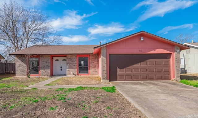 ranch-style house with central AC unit, concrete driveway, brick siding, and an attached garage