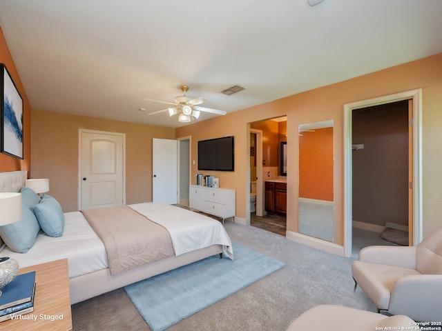 bedroom with visible vents, light carpet, baseboards, and ensuite bathroom