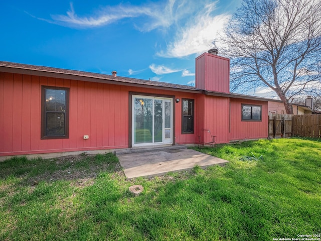 back of house with a patio area, a chimney, fence, and a yard