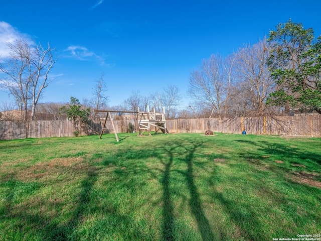 view of yard featuring a fenced backyard and a playground