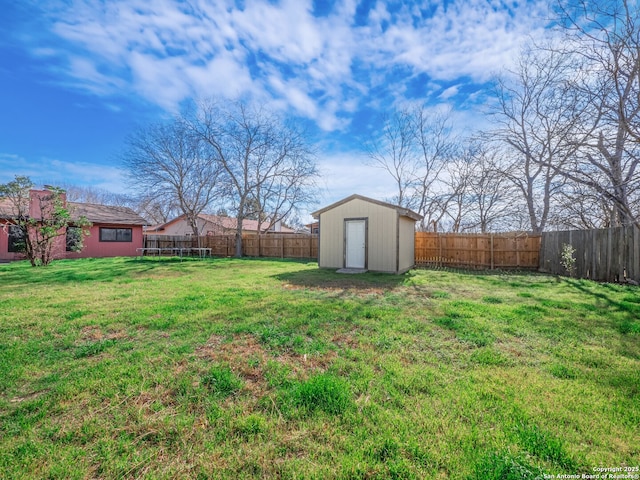 view of yard featuring a fenced backyard, an outbuilding, and a shed