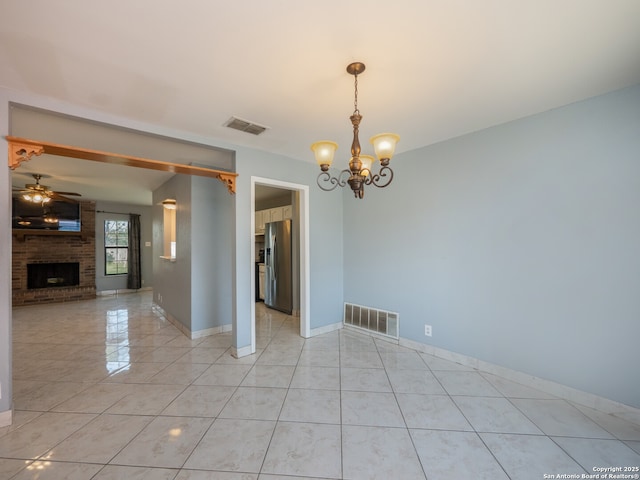 interior space featuring light tile patterned flooring, a brick fireplace, visible vents, and ceiling fan with notable chandelier