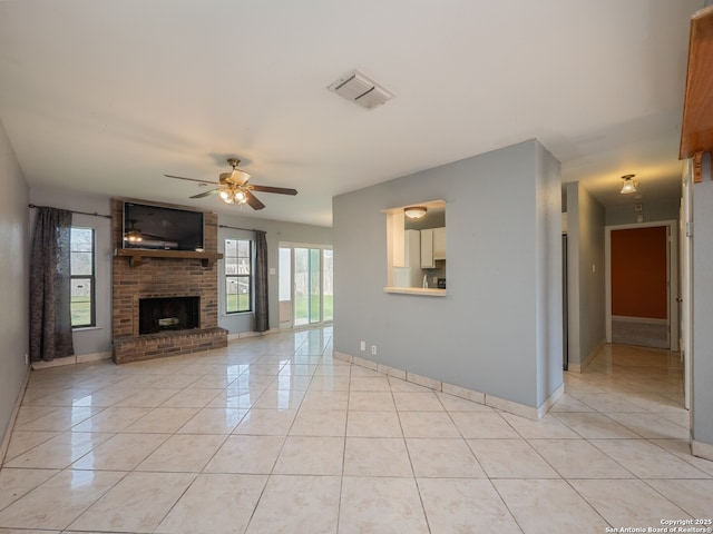 unfurnished living room featuring light tile patterned floors, a brick fireplace, visible vents, and a ceiling fan