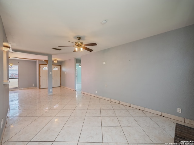 spare room with light tile patterned floors, ceiling fan, visible vents, and baseboards