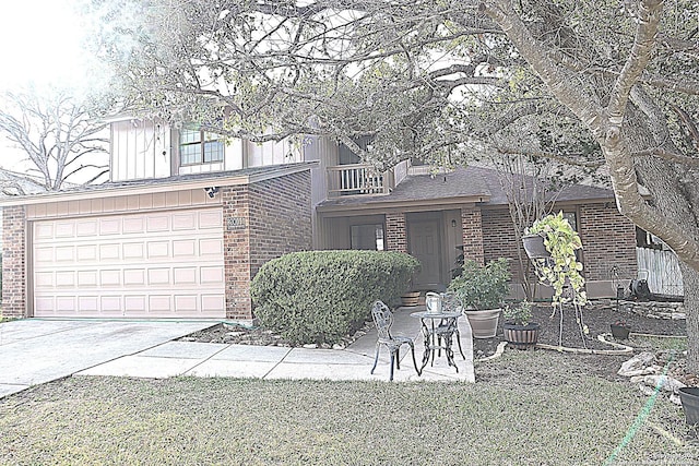 view of front of property featuring a garage, brick siding, driveway, and a balcony