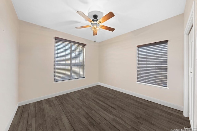 unfurnished room featuring dark wood-style floors, ceiling fan, and baseboards