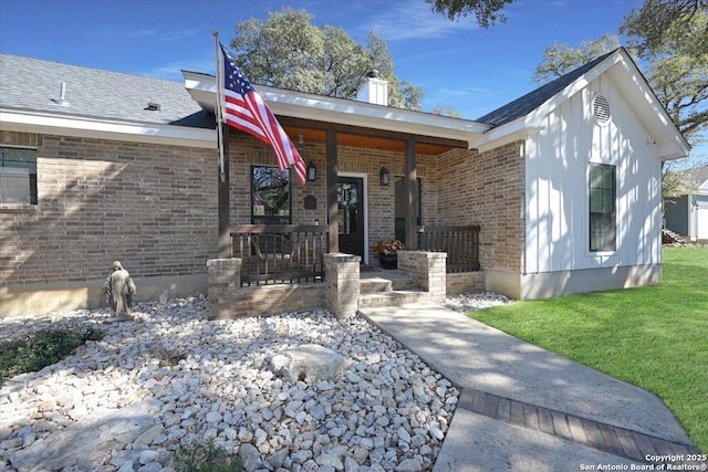 view of front of house with a front lawn, a porch, and brick siding