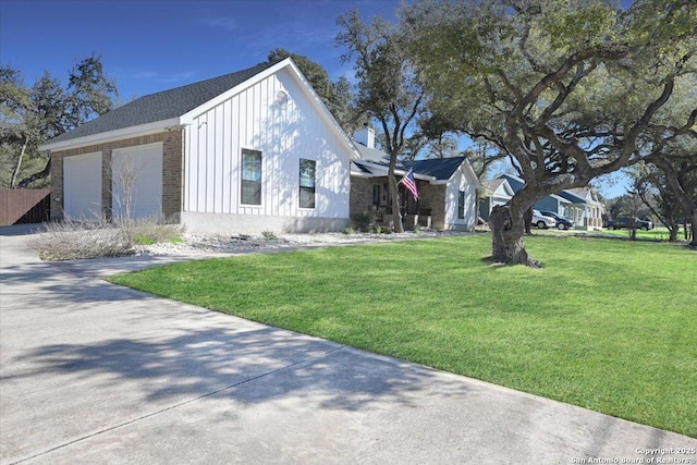 view of home's exterior featuring a garage, brick siding, a yard, concrete driveway, and board and batten siding