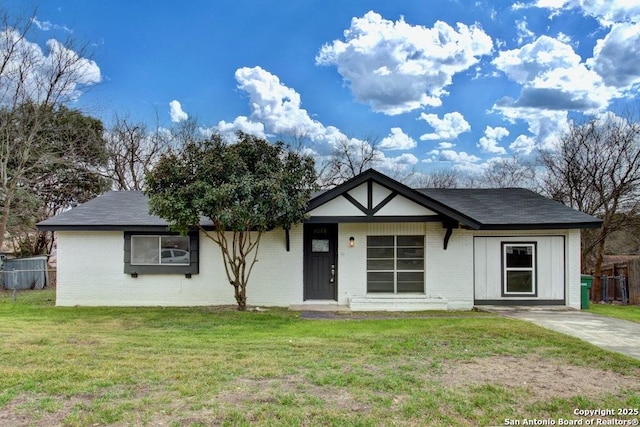 view of front of house with fence, a front lawn, and brick siding