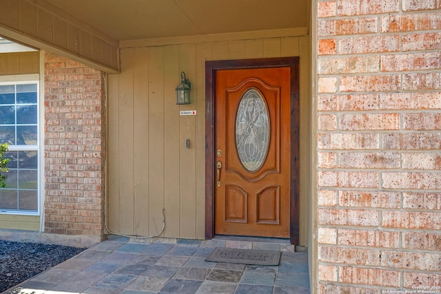 view of exterior entry featuring brick siding