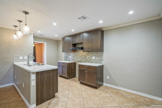 kitchen with tasteful backsplash, light countertops, visible vents, and crown molding