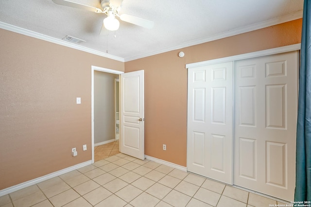 unfurnished bedroom featuring light tile patterned flooring, visible vents, baseboards, a closet, and crown molding