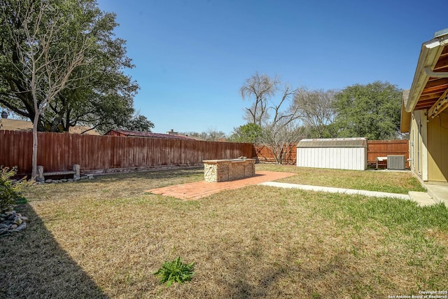 view of yard featuring a fenced backyard, an outdoor structure, and central AC unit