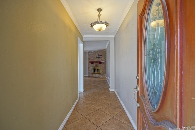 interior space with a fireplace, crown molding, baseboards, and light tile patterned floors