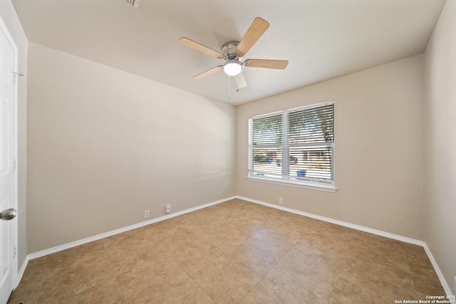 unfurnished room with ceiling fan and baseboards