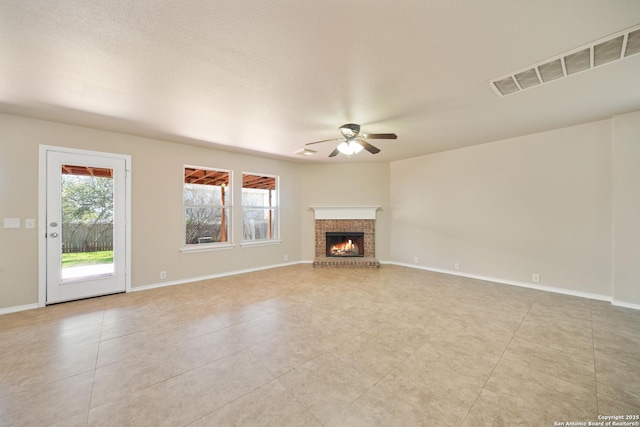 unfurnished living room with visible vents, a fireplace, and baseboards