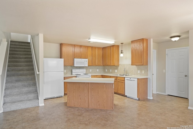 kitchen with light countertops, white appliances, a center island, and decorative backsplash