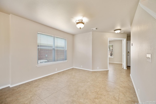 spare room with light tile patterned floors, visible vents, and baseboards