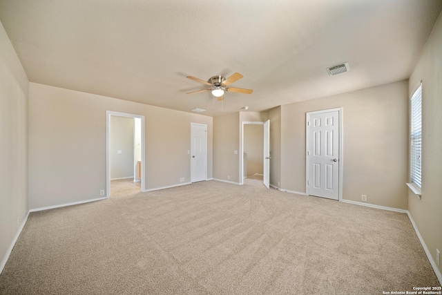 unfurnished bedroom with ceiling fan, light colored carpet, visible vents, and baseboards