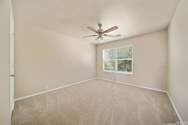 empty room with ceiling fan, carpet flooring, visible vents, and baseboards