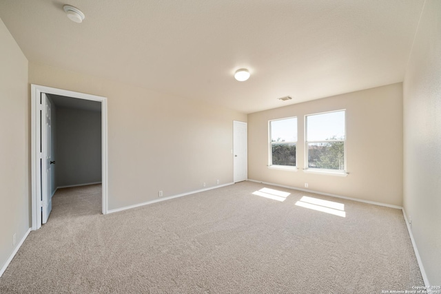 carpeted empty room featuring visible vents and baseboards