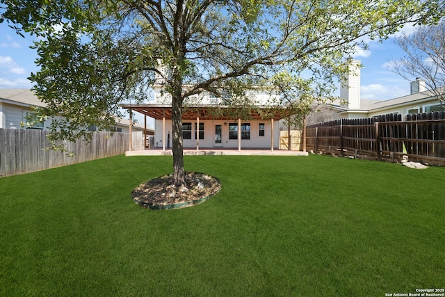 back of property featuring a patio area, a yard, and a fenced backyard