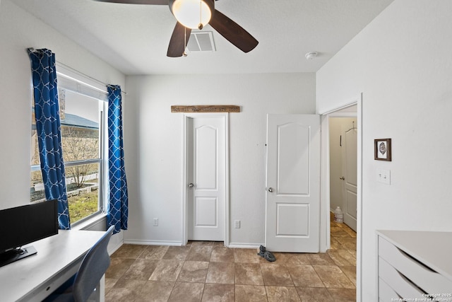 office space featuring visible vents, ceiling fan, and baseboards