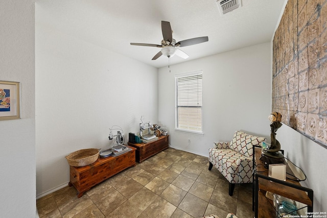 living area with ceiling fan, visible vents, and baseboards