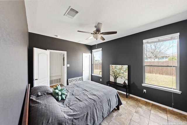 bedroom featuring a ceiling fan, visible vents, and baseboards