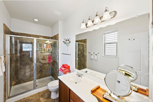 full bathroom featuring toilet, a stall shower, and vanity