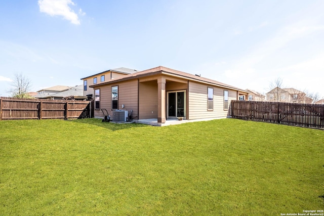 rear view of house with a yard, cooling unit, and a fenced backyard