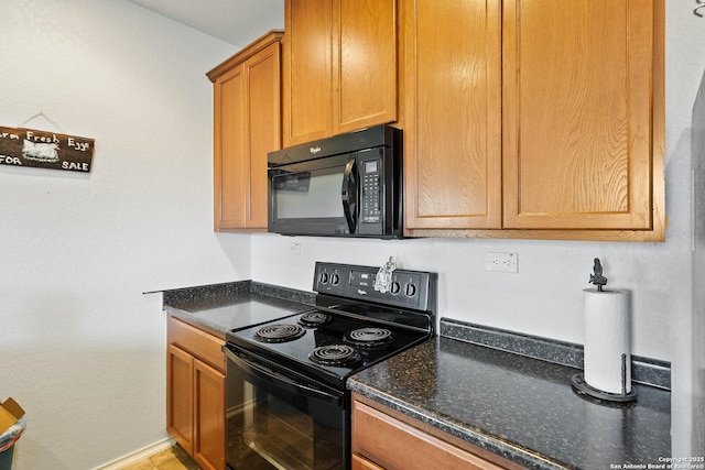 kitchen with brown cabinets, dark stone counters, baseboards, and black appliances