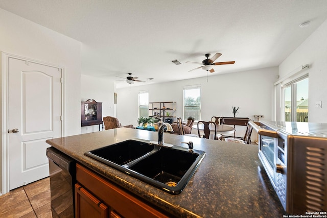 kitchen with black dishwasher, visible vents, a ceiling fan, open floor plan, and a sink