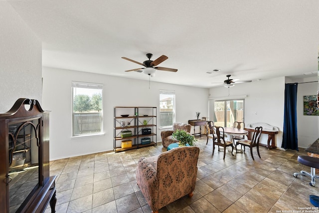 living area featuring ceiling fan and visible vents