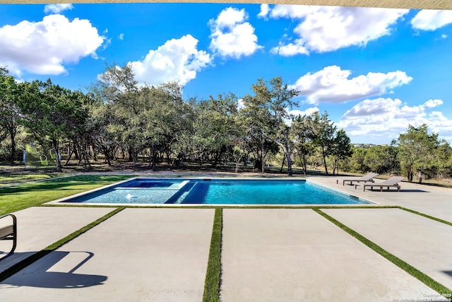 outdoor pool with a patio and an in ground hot tub