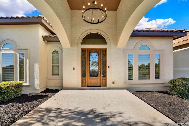 property entrance featuring stucco siding and a tiled roof