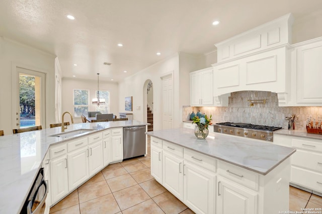 kitchen featuring tasteful backsplash, appliances with stainless steel finishes, light stone counters, a sink, and light tile patterned flooring