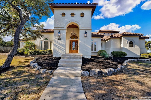 mediterranean / spanish-style home with a tile roof and stucco siding