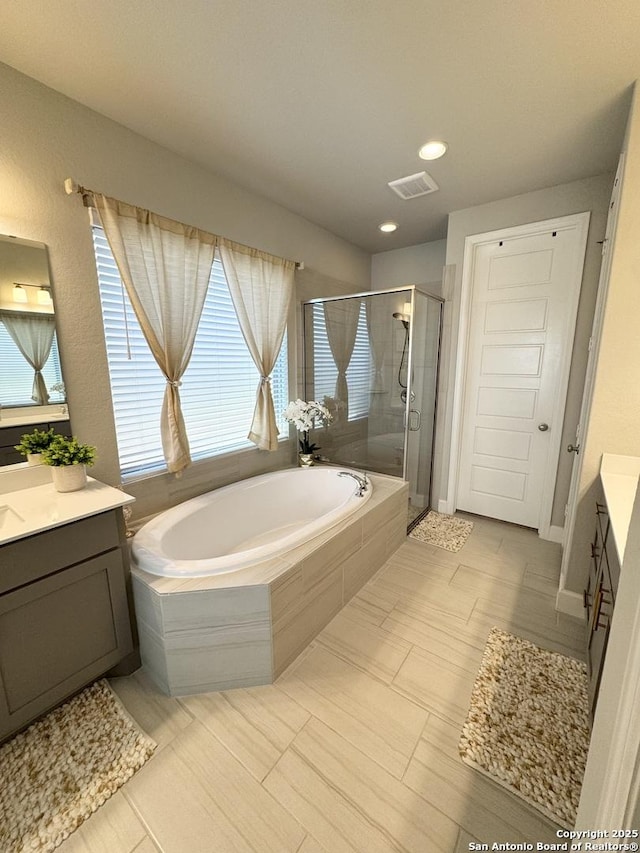 bathroom with a shower stall, visible vents, a bath, and vanity